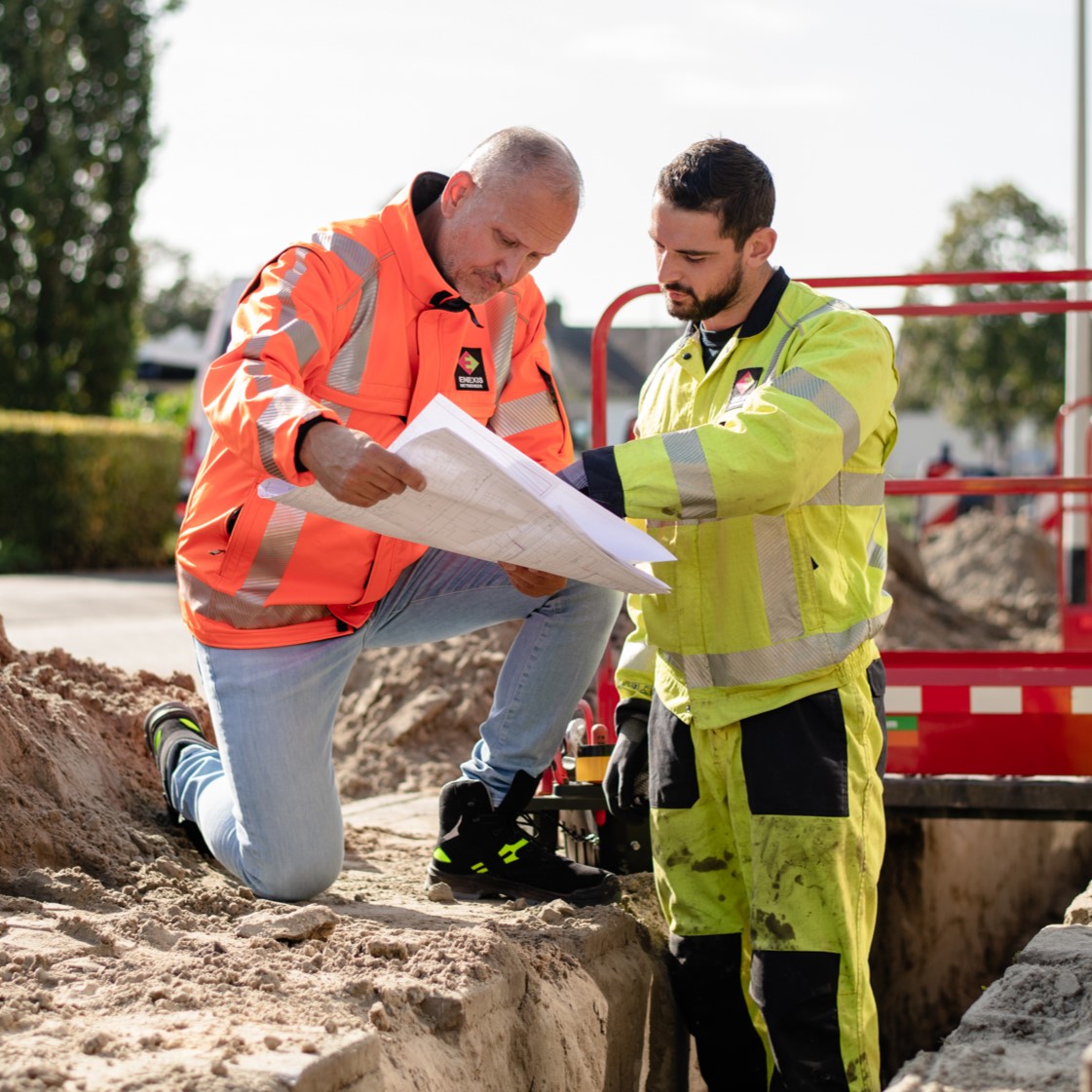 Monteurs van Enexis overleggen tijdens grondwerkzaamheden in de straat