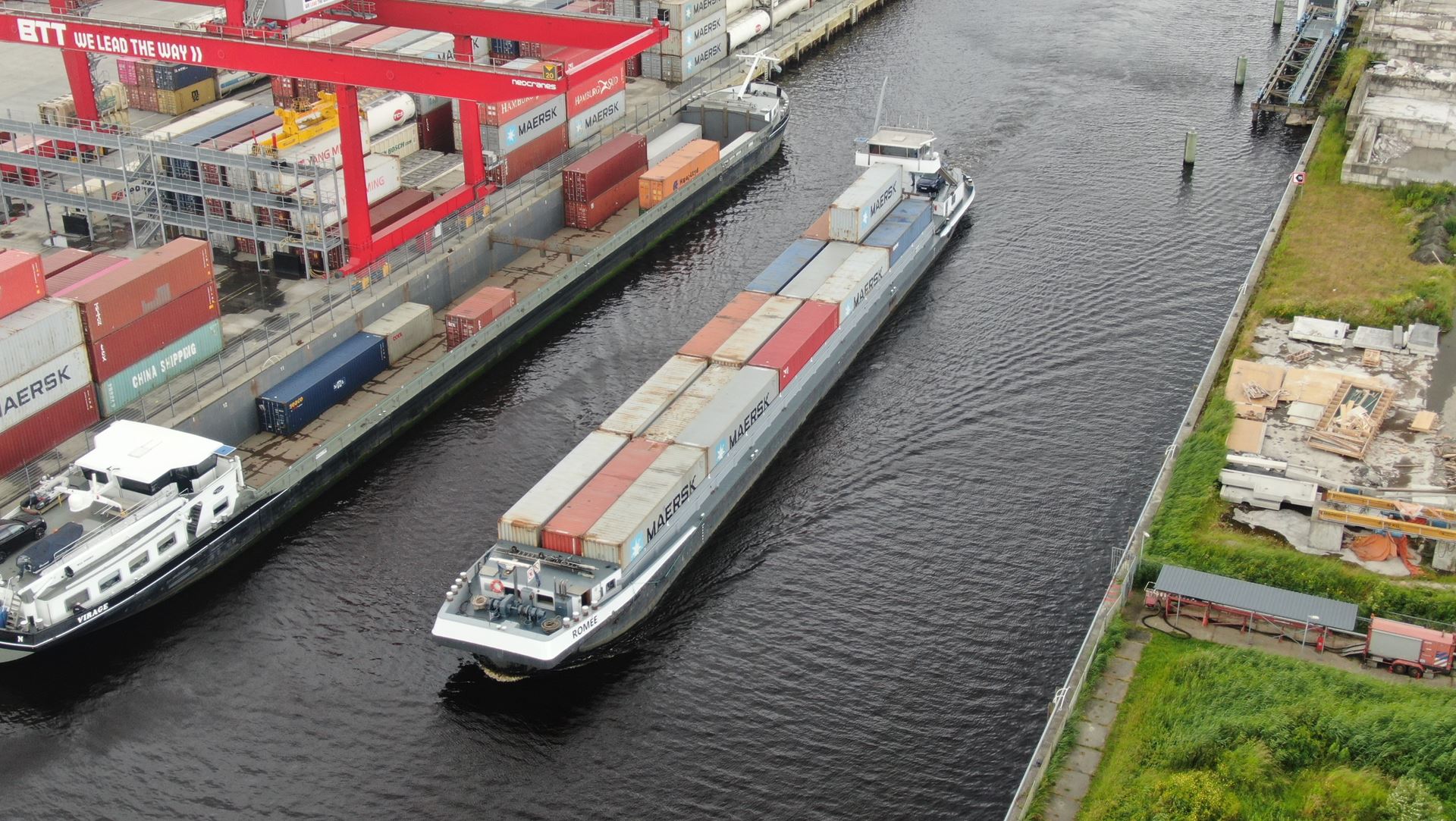 Containerschip varend in kanaal gezien van bovenaf