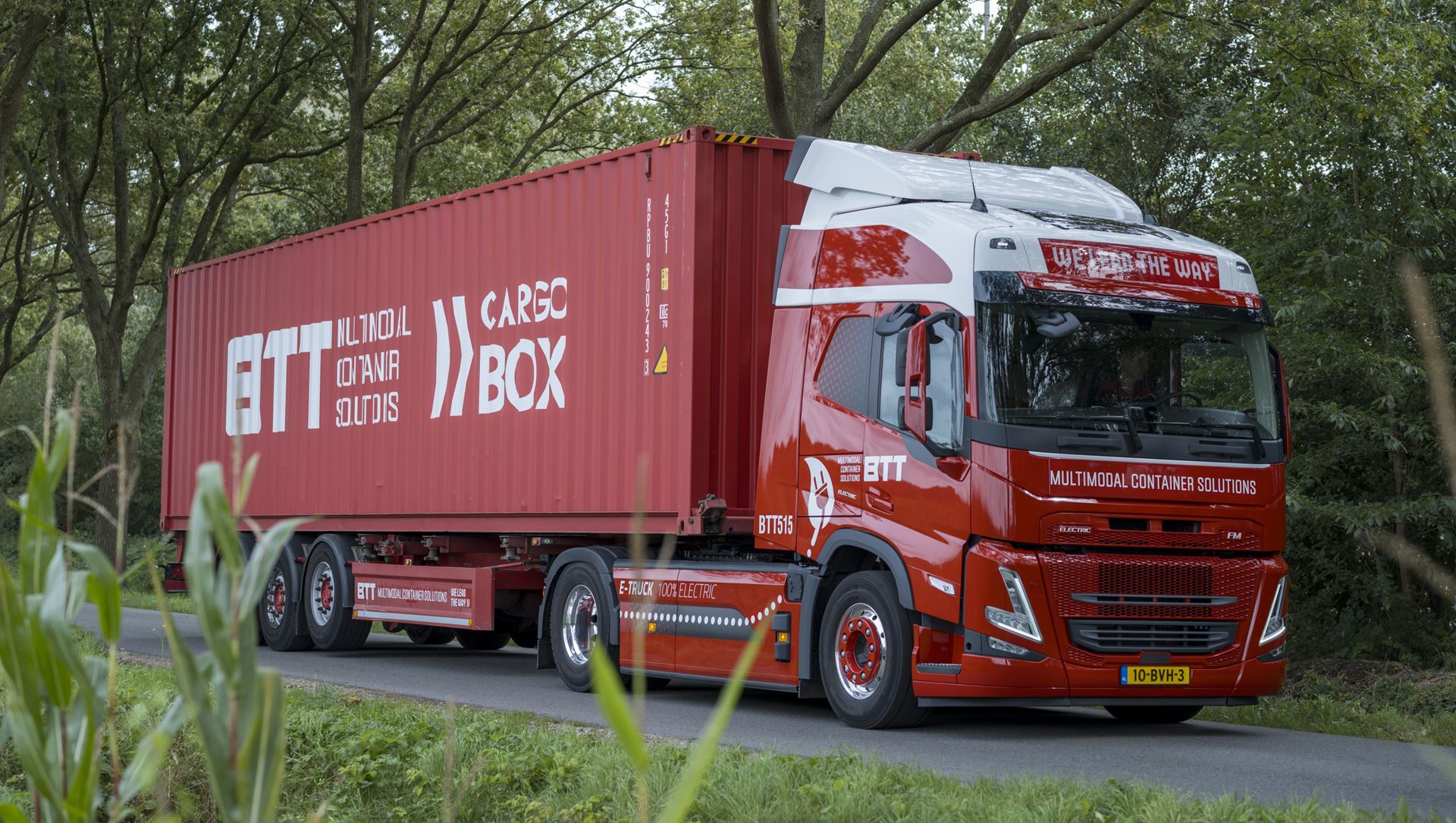 Vrachtauto met container rijdend op een landweg