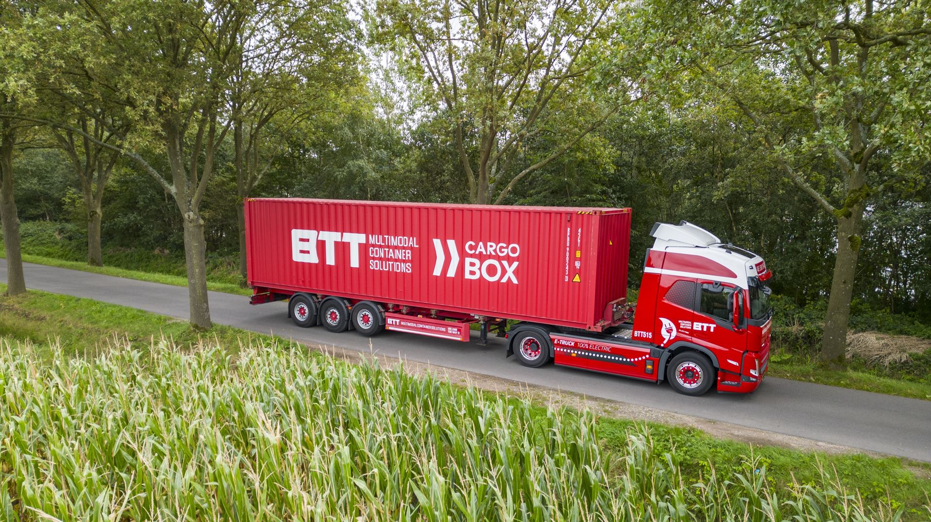 Vrachtwagen met container rijdend op een landweg