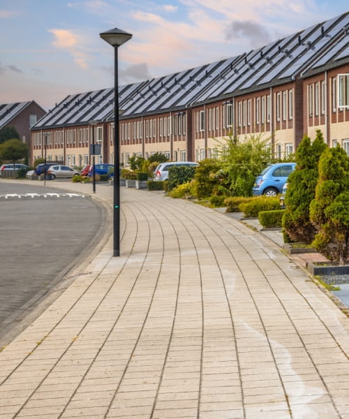 Straat met autos en huizen met zonnepanelen